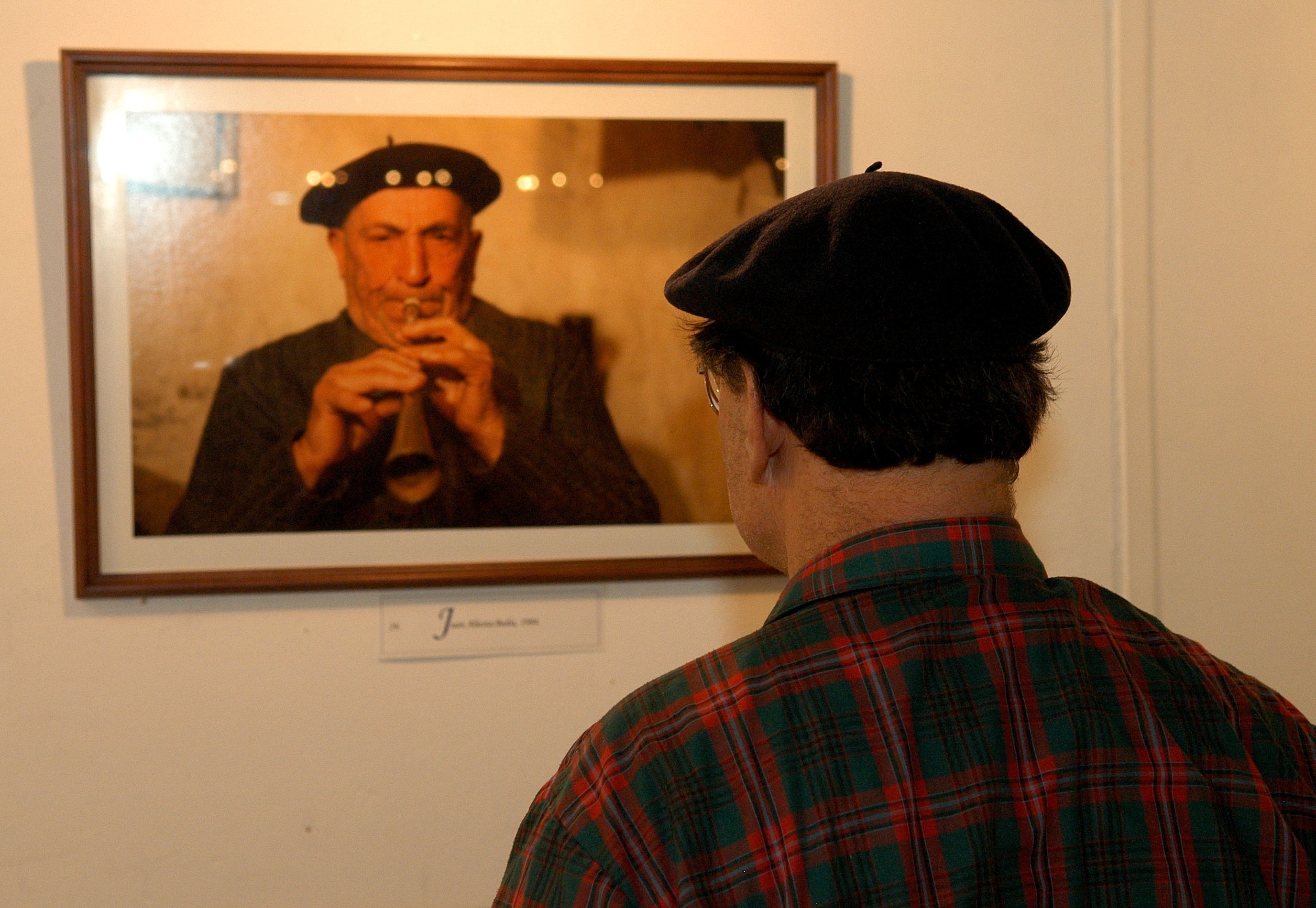 Uno de los visitantes observa una de las fotografías de la muestra (foto Euskal Erria EE)